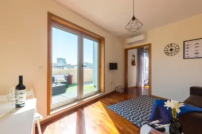 a living room with a large window and a couch at Music Relaxing Apt with bikes, terrace & parking in Porto