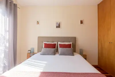 a bedroom with a large white bed with red pillows at Music Relaxing Apt with bikes, terrace & parking in Porto