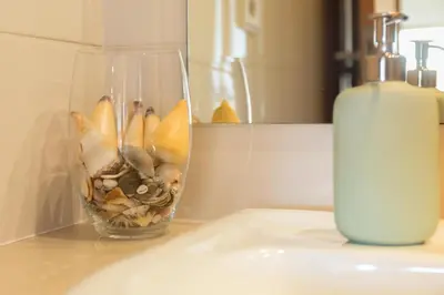 a vase filled with shells on a counter next to a candle at Music Relaxing Apt with bikes, terrace & parking in Porto