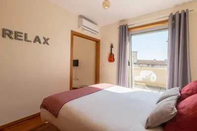 a bedroom with a bed and a large window at Music Relaxing Apt with bikes, terrace & parking in Porto
