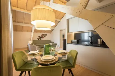 a kitchen and dining room with a glass table and green chairs at Santa Catarina Apartments in Porto