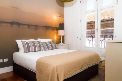 a bedroom with a large bed with a large window at Liiiving in Porto | Ribeira Boutique Apartment in Porto