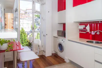 a kitchen with red cabinets and a washing machine at Liiiving in Porto | Ribeira Boutique Apartment in Porto