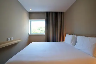a bedroom with a large white bed with a window at Spot Family Apartments in Porto