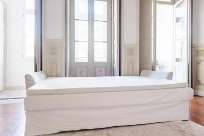 a large white bed in a room with windows at Get a Unique and Luxury Flat in Porto