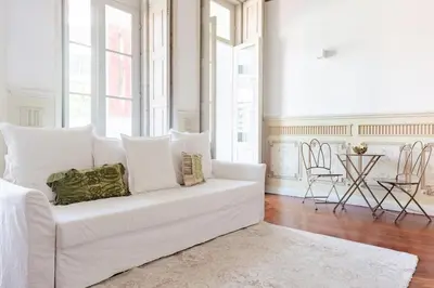 a white couch in a living room with windows at Get a Unique and Luxury Flat in Porto