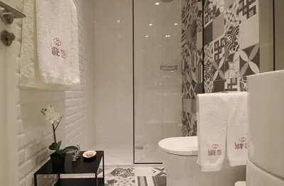 a bathroom with a toilet and a glass shower at HM - The Garden in Porto