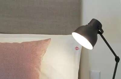 a black lamp sitting next to a bed with a pillow at HM - The Garden in Porto