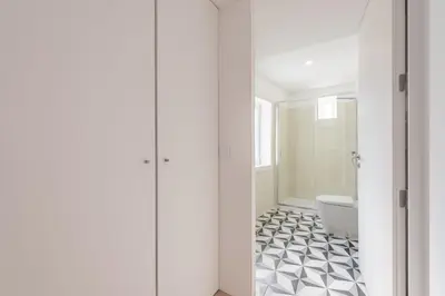 a bathroom with a white toilet and a black and white tile floor at Sá de Noronha Mezzanine w Terrace in Porto