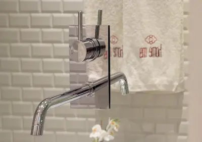 a bathroom sink with a shower head and a towel at HM - Pinheiro Cosy Apartment in Porto
