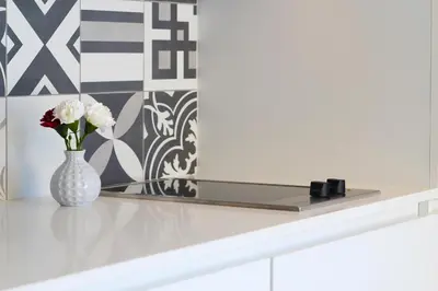 a kitchen with white cabinets and a sink at HM - Pinheiro Cosy Apartment in Porto