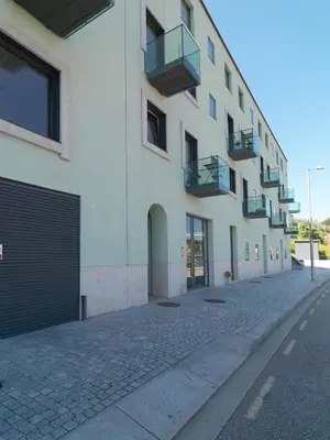a large white building with doors and balconies on a street at FLH Luxury Porto River View in Vila Nova de Gaia