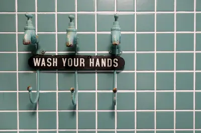 a sign that reads wash your hands hanging on a wall at Porto Duke's House in Porto