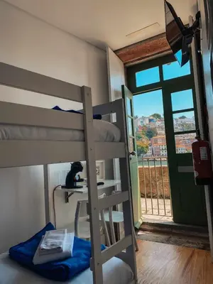 a bedroom with a bunk bed with a cat sitting on a desk at Panorama Apartments Ribeira Porto in Porto