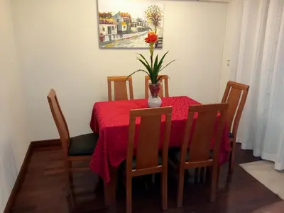 a dining room table with a vase of flowers on it at Apartamento Alvares Cabral in Vila Nova de Gaia