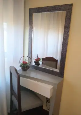 a mirror on a wall with a table and a chair at Apartamento Alvares Cabral in Vila Nova de Gaia