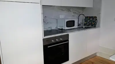 a kitchen with a microwave and a black oven at Oporto Cosy Apartment at Alegria in Porto