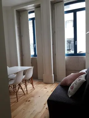 a living room with a table and chairs and windows at Oporto Cosy Apartment at Alegria in Porto