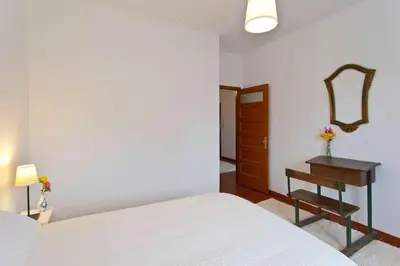 a bedroom with a bed and a table and a mirror at Camarao Apartment in Porto
