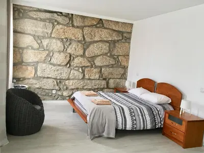 a bedroom with a bed and a stone wall at Campanhã Boutique Station in Porto