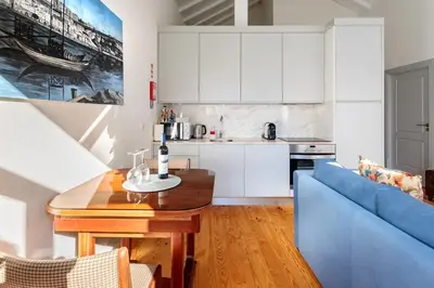 a kitchen and living room with a blue couch and a table at AmaOporto - St. Ildefonso in Porto