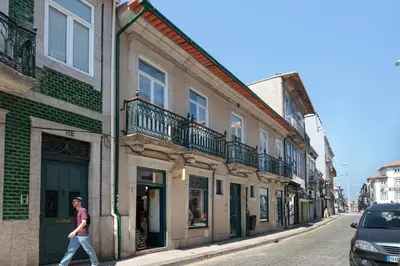 a man walking down a street next to buildings at AmaOporto - St. Ildefonso in Porto