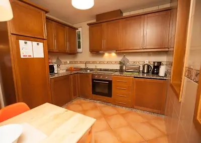 a kitchen with wooden cabinets and a wooden table at ML Formosa Deluxe Rooms in Porto