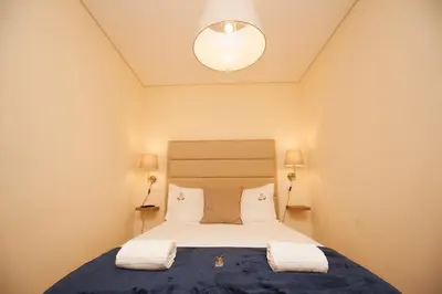a bedroom with a bed with two towels on it at ML Formosa Deluxe Rooms in Porto