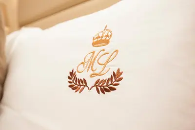 a crown embroidered on the side of a white shirt at ML Formosa Deluxe Rooms in Porto
