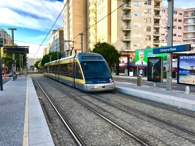 a train is on the tracks in a city at Porto Garden Villas | Downtown in Vila Nova de Gaia