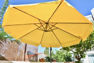 a yellow umbrella sitting on top of a table at Porto Garden Villas | Downtown in Vila Nova de Gaia