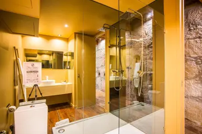 a bathroom with a glass shower and a toilet at Laurear Guest House in Porto