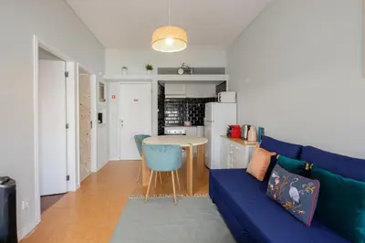 a living room with a blue couch and a table at GuestReady - Back to Little World in Porto