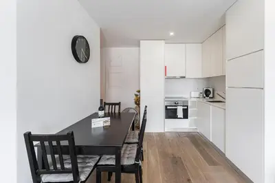 a kitchen and dining room with a black table and chairs at GuestReady - Cosy spot near Porto city centre in Porto