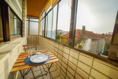 a table with a plate on it on a balcony at Quarto com 4 camas (Beliches+ 1 Sofá-cama) in Porto