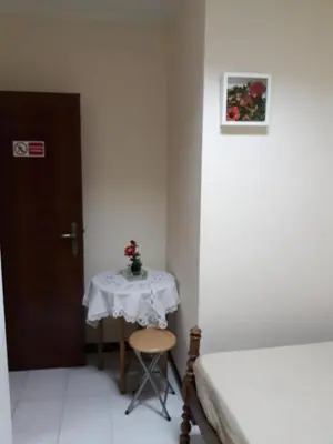 a room with a table and a bed and a table and a door at Quarto com 4 camas (Beliches+ 1 Sofá-cama) in Porto
