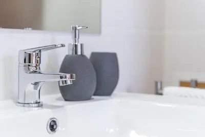 a bathroom sink with two soap dispensers on a counter at GuestReady - Given to fly in Porto