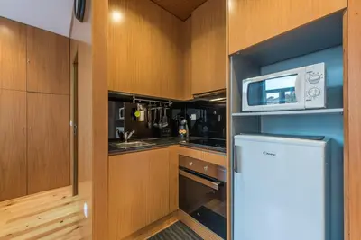 a kitchen with wooden cabinets and a microwave at GuestReady - Given to fly in Porto