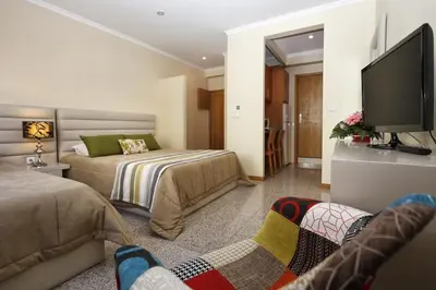 a bedroom with two beds and a flat screen tv at Oporto City Centre Apartments in Porto