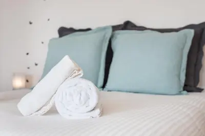 a pile of towels on a bed with pillows at GuestReady - Porto Magic View in Vila Nova de Gaia