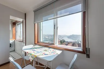 a dining room with a table and a large window at GuestReady - Porto Magic View in Vila Nova de Gaia
