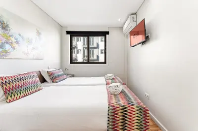 a white bedroom with a bed and a window at GuestReady - Jupiter's Moon in Porto