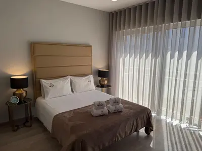 two stuffed animals sitting on a bed in a bedroom at ML Apartments Almada panoramic balcony in Porto