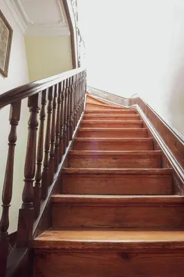 a wooden staircase with a wooden railing and a door at 57 in Porto