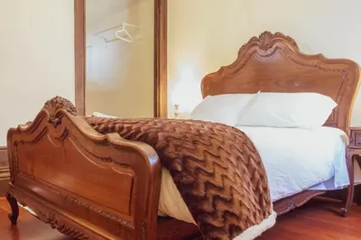 a bedroom with a wooden bed with a large mirror at 57 in Porto