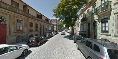 a hallway with a wooden door and stairs with plants at 57 in Porto