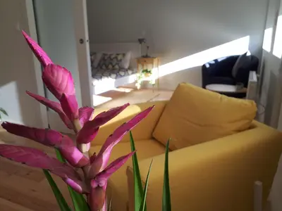 a living room with a yellow couch and a pink flower at Porto Nascente in Porto
