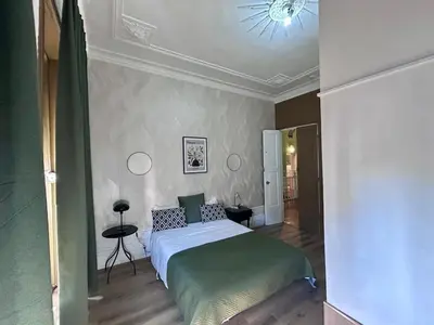 a bedroom with a bed and a chandelier at Monte Sinai Guest House in Porto