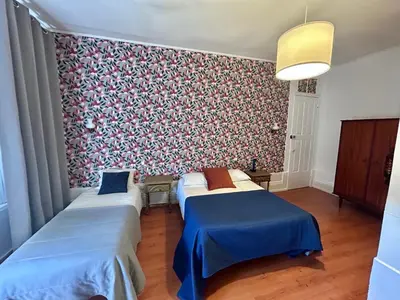 two beds in a room with a floral wallpaper at Monte Sinai Guest House in Porto