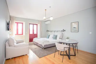 a bedroom with a bed and a table and a couch at Liiiving in Porto - Historic Clérigos Apartments in Porto